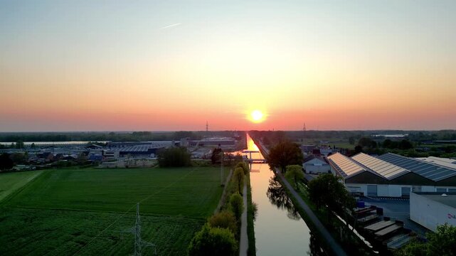 Sint Jozef, Rijkevorsel, Antwerp, Belgium, 27th of April, 2025, Breathtaking sunrise reflecting on calm waters, surrounded by lush green fields and serene architecture.