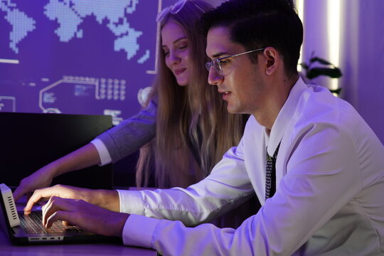 Male staff members chat with female employees, discuss in front of computer screens, brainstorm, consult, research together, and present information to the company meeting in the evening.