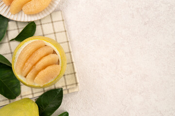 Fresh pomelo fruit with leaf on white table background.