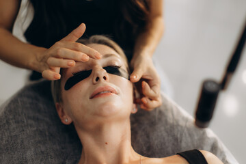 Naklejka premium Woman receiving led eyelash extension beauty treatment