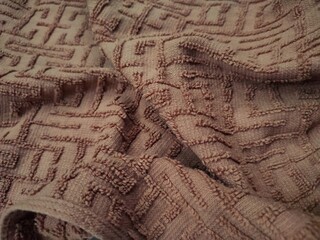 Fototapeta premium texture and background of a brown towel with a maze-like winding line pattern