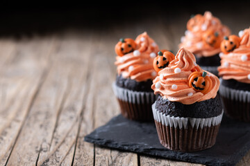 Halloween cupcakes with Halloween sprinkles on wooden table. Copy space