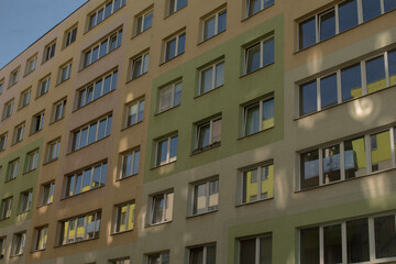 Facade wall of a residential building with visible play of light and shadow. Urban housing architecture, reflecting everyday residential environment and visual contrasts in city landscapes.