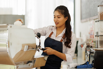 Asian female barista holding a tablet to check orders from customers barista cafe owner. SME entrepreneur seller business concept
