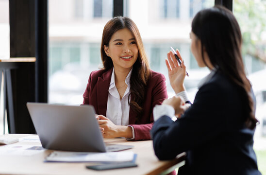 Two asian Business financial, accountant discussing with partner are meeting to audit finance planning sales to meet targets set in next year. stock market concept..
 - Powered by Adobe