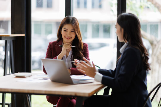 Two asian Business financial, accountant discussing with partner are meeting to audit finance planning sales to meet targets set in next year. stock market concept..
