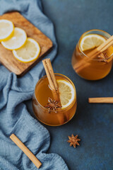 Warm spiced drinks with cinnamon sticks lemon slices and star anise