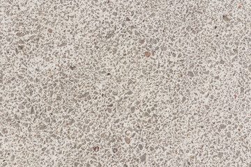 Beautiful cement background with fragments of fine natural stone. The texture of a natural stone surface. Texture of urban road surface. A copy space