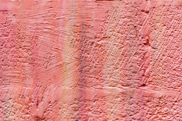 Abstract background of painted stone wall in pink. Shades of orange color of the stone wall texture. A beautiful background space for design.