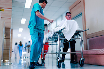 Team medical staff pushing stretcher gurney bed with injured patient to emergency room in hospital. Group of multiracial doctor and nurse work together at professional medical clinic. Health care ward