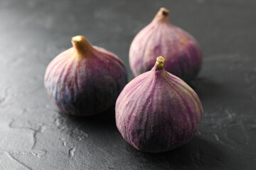 Obraz premium Fresh ripe figs on dark textured table, closeup
