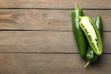 Fresh jalapeno peppers on wooden table, top view. Space for text