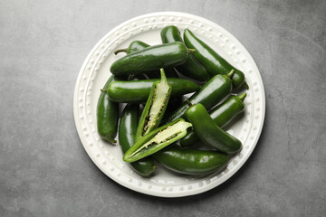 Ripe green jalapeno peppers on grey table, top view