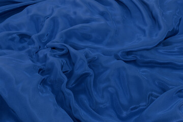 Abstract blue fabric texture with smooth swirl folds, creating a soft flowing background for design, wallpaper, or creative presentation. 3d render