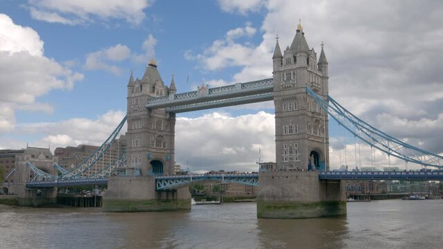 Hyperlapse captures Tower Bridge stretching over the River Thames in London, with twin Gothic towers, blue suspension elements, and reflections on the flowing water below