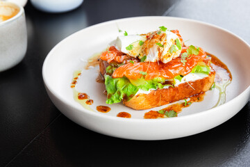 A gourmet open-faced toast features smoked salmon and creamy cheese