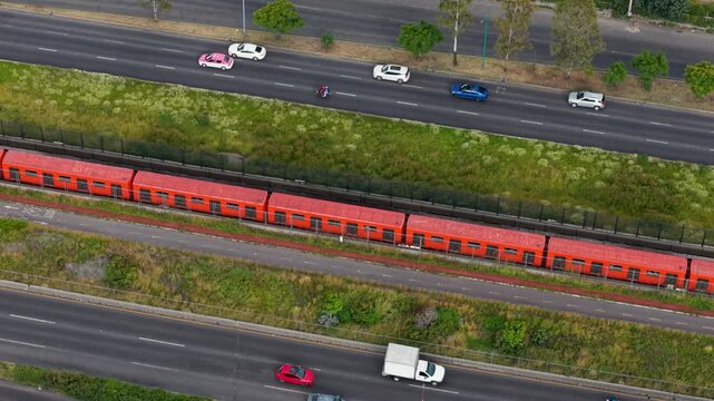 Drone footage of orange Mexico City Metro train on Ecatepec Avenue