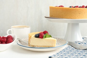 Delicious cheesecake with fresh berries and mint served on white table