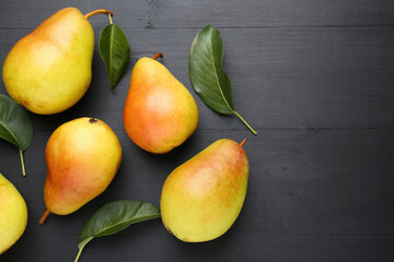 Many fresh pears and leaves on black table, flat lay. Space for text