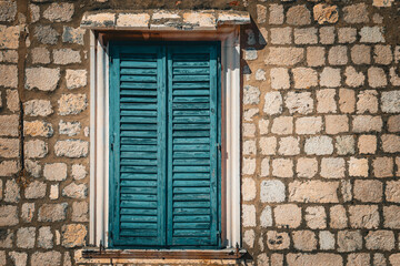 Rustic Stone Wall with Weathered Blue Wooden Shutters