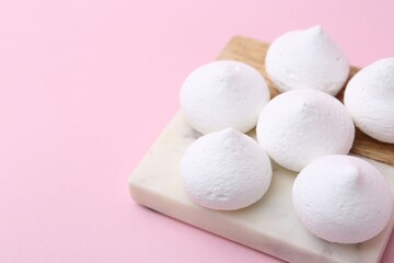 Many yummy meringue cookies on pink background, closeup. Space for text
