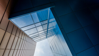 bottom view of the windows and walls of a tall business building in a modern city