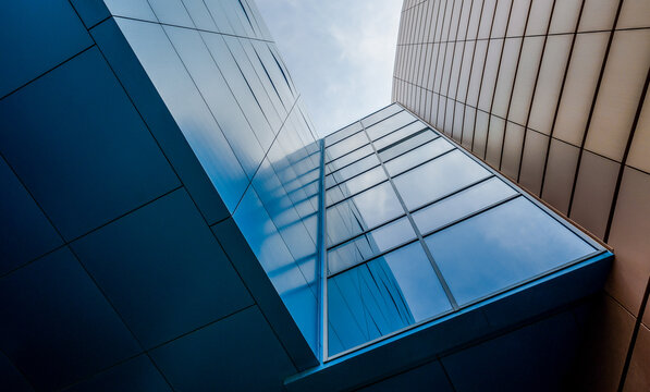 bottom view of the windows and walls of a tall business building in a modern city