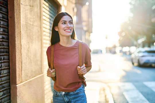 Fototapeta Portrait of a smiling young woman girl walking in the city, tourists visiting destination, summer trip exploring