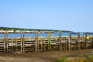 Fototapeta premium World's highest and lowest tides: a wharf in Westport Nova Scotia at low tide in August room for text