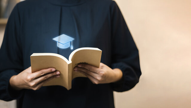 Graduation cap hologram above book, education and e-learning inspiration