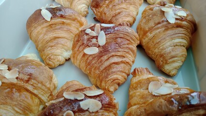Golden fresh croissant, exquisitely baked, offers tempting sweet treat. Each delicious pastry features crunchy almond flakes and subtle hint of honey glaze, perfect for delightful morning