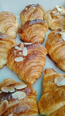 Golden almond croissant, freshly baked, offers joyful breakfast experience. sweet honey aroma and warm pastry create delightful start. Each flaky croissant, topped with crunchy almond slices