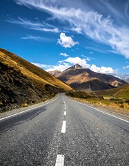 Mountain road stretches into a clear blue sky