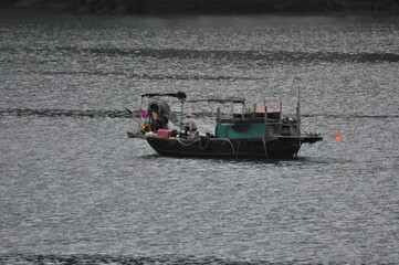 fisherman and his boat at Halong Bay Vietnam