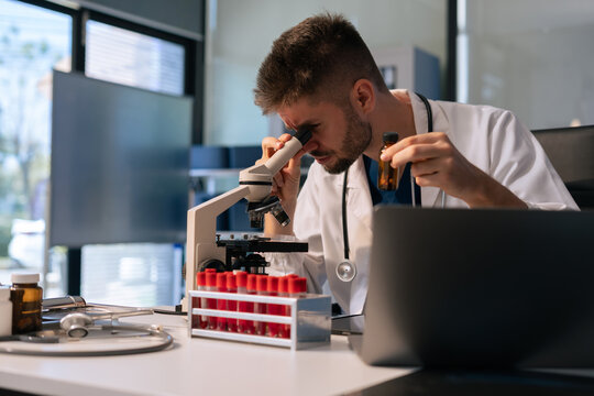 Lab work, Doctor holds a test tube takes the test from a test tube in analysis, blood, DNA, test tube stand. - Powered by Adobe