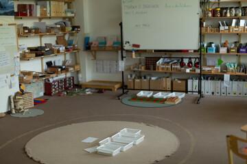 An organized and attractive classroom with shelves of educational materials and a spacious area for group activities