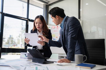 Business team discusses startup strategy with investor using tablet, laptop, and smartphone.
