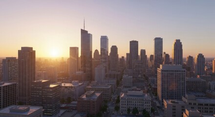 Aerial cityscape at sunrise.  Urban skyline with numerous high-rise buildings.  Golden sunlight illuminates the buildings.  Soft, diffused light