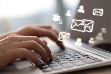 Close-up of hands typing on a laptop with email icons overlay