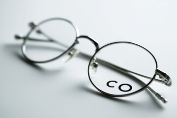 Close-up of round eyeglasses, light gray metal frame, clear lenses, simple design