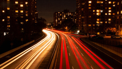 Nighttime city highway with light trails from moving vehicles