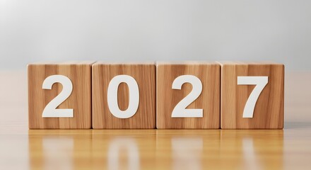 Four wooden blocks displaying the year two thousand and twenty seven on a wooden surface indoors