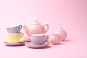 Beautiful tea set on pink background, space for text. Child's toy