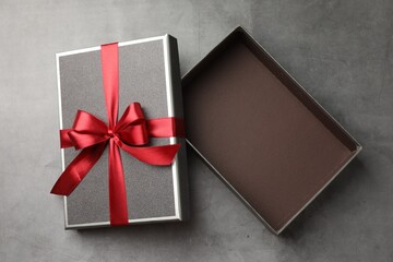 Opened gift box with beautiful lid on grey table, top view