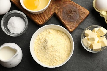 Cornbread preparation. Different ingredients on black textured table, flat lay