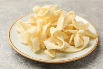 Tasty dried shredded squid on grey table, closeup