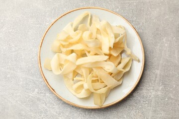 Tasty dried shredded squid on grey table, top view