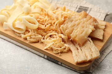 Tasty dried squid on grey table, closeup