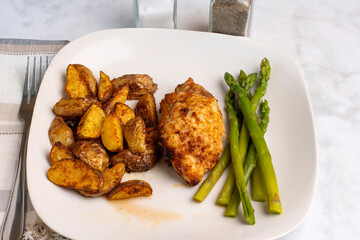 chicken thigh   with  potato wedges and asparagus
