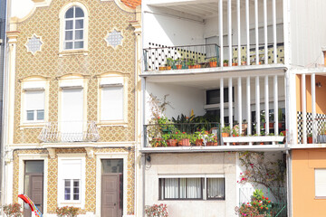 Traditional tiled facade and modern balcony with plants in Aveiro, Portugal, showcasing contrast of architecture and authentic urban lifestyle.